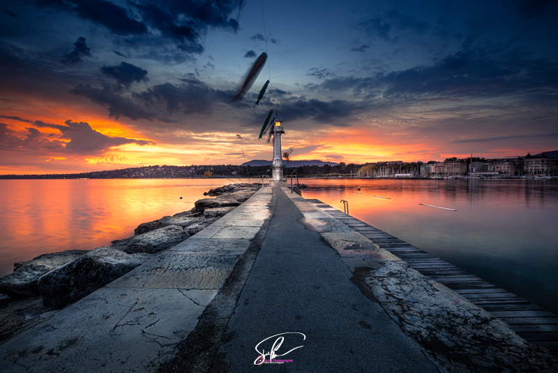 photographie du lever de soleil sur le phare du bain des paquis a geneve
